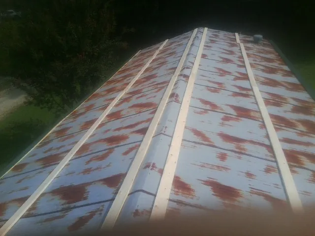 Rusted metal roof panels with new wood purlins before replacement — Storm Damage Roof Repair in Dowelltown by Roofing Brothers