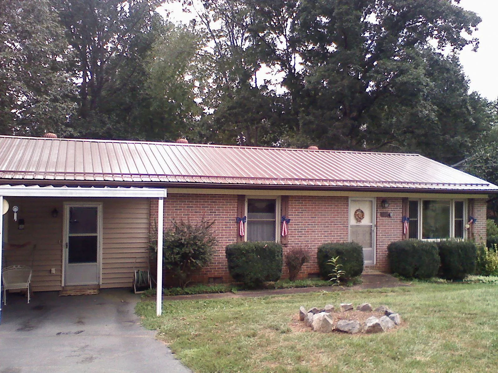 Bronze metal roof and carport on a brick ranch home — Roof Repair work by our crew in Dowelltown